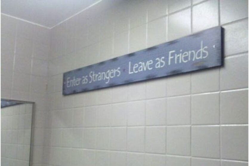 funny bathroom sign-enter as strangers leave as friends image